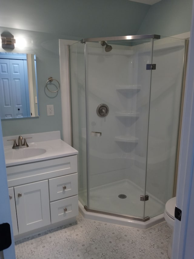 bathroom featuring a stall shower, vanity, and toilet