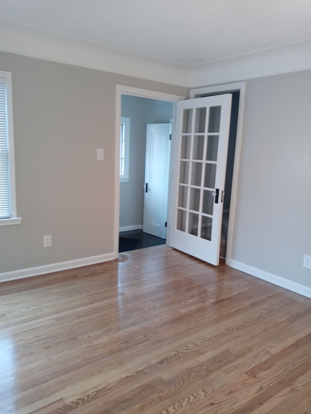 spare room featuring light wood-type flooring and baseboards