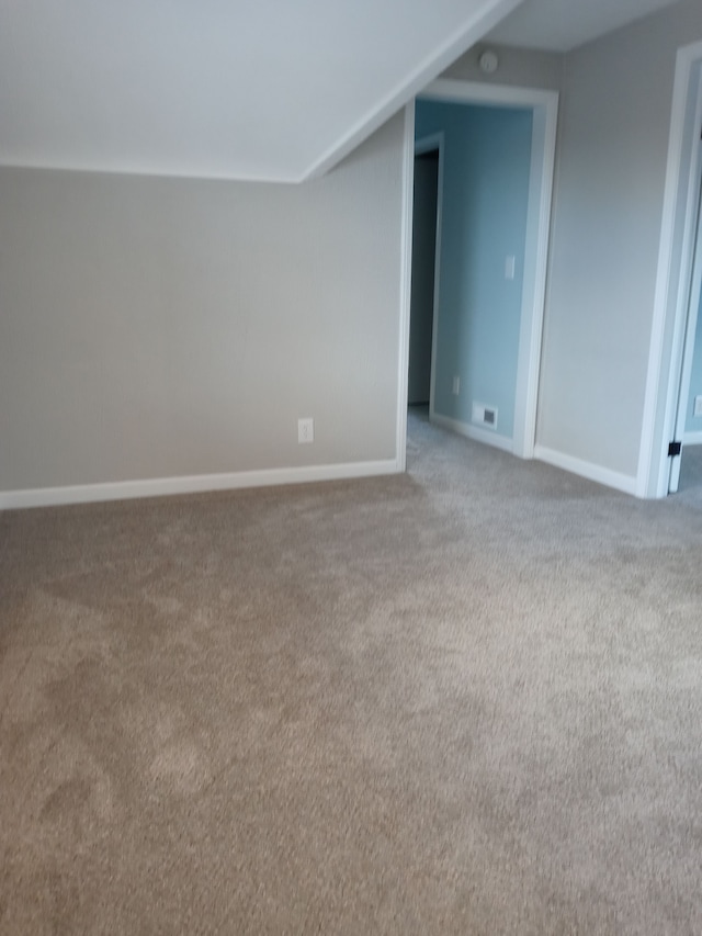 additional living space with carpet floors, baseboards, and visible vents