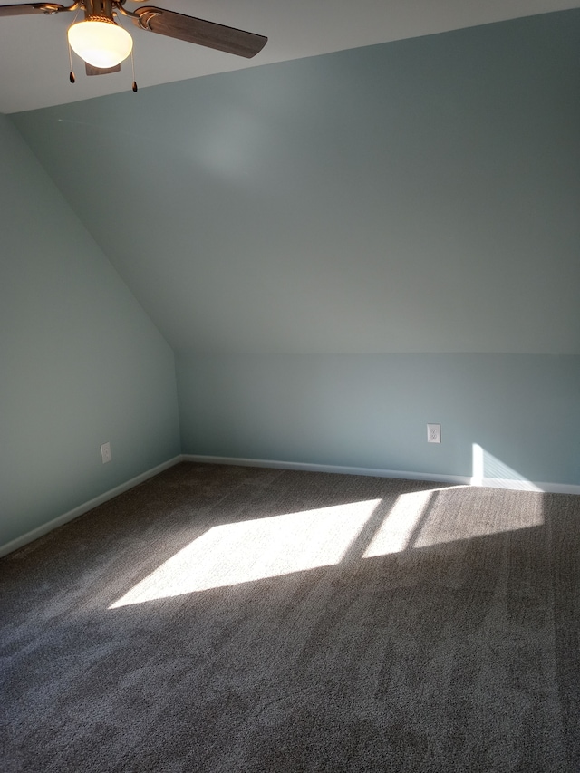 additional living space featuring carpet, vaulted ceiling, baseboards, and ceiling fan