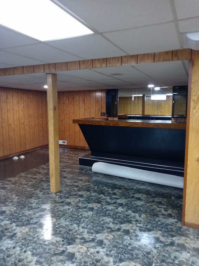 bar with a paneled ceiling and wood walls