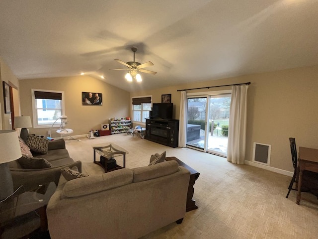 living room featuring a healthy amount of sunlight, light carpet, vaulted ceiling, and visible vents