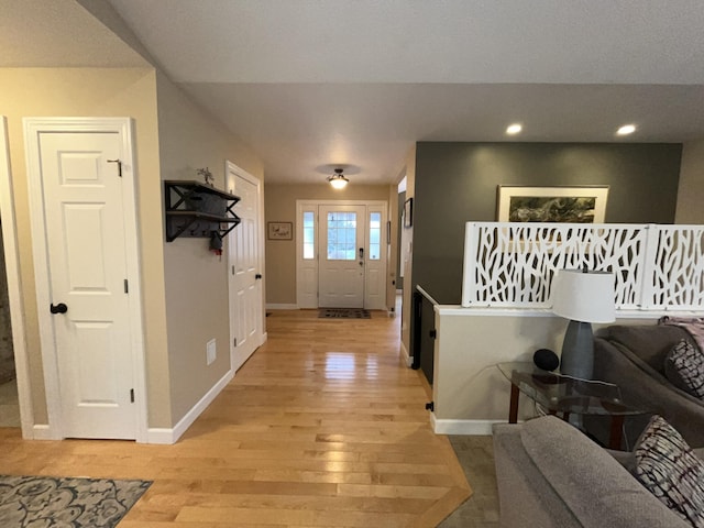 hall featuring light wood-style floors, recessed lighting, and baseboards