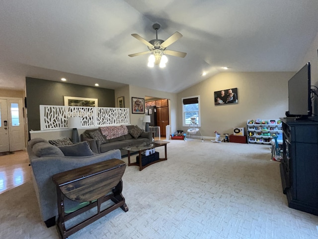 living area featuring lofted ceiling, light carpet, baseboards, and a ceiling fan