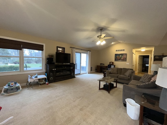 living room featuring lofted ceiling, ceiling fan, visible vents, and light colored carpet