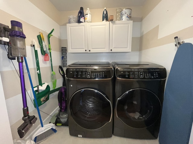 washroom featuring washing machine and clothes dryer and cabinet space