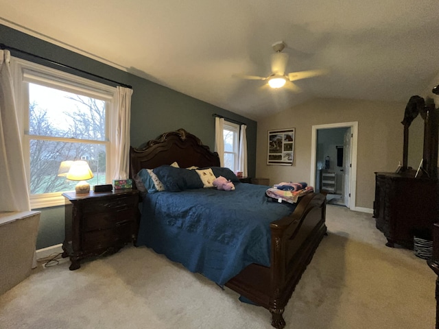 bedroom with lofted ceiling, ceiling fan, multiple windows, and light colored carpet