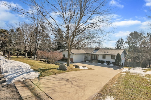 view of front of home featuring a garage, fence, concrete driveway, a front lawn, and a chimney