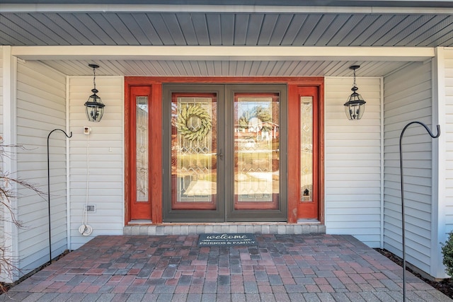 doorway to property with uncovered parking and a porch