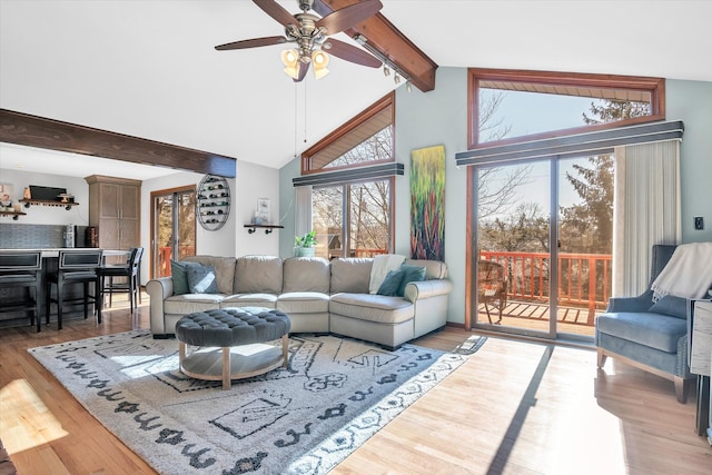 living room with a ceiling fan, beamed ceiling, high vaulted ceiling, and wood finished floors