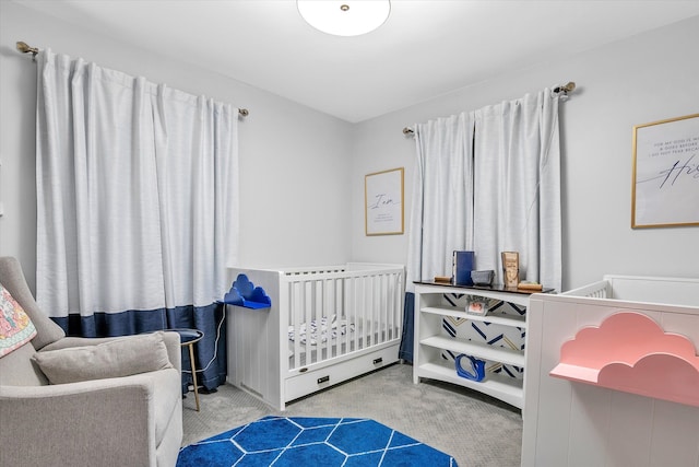 carpeted bedroom featuring a nursery area