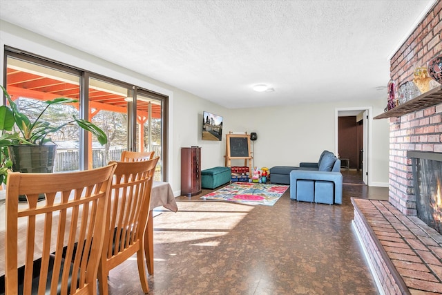 living room featuring a textured ceiling, a brick fireplace, and tile patterned floors