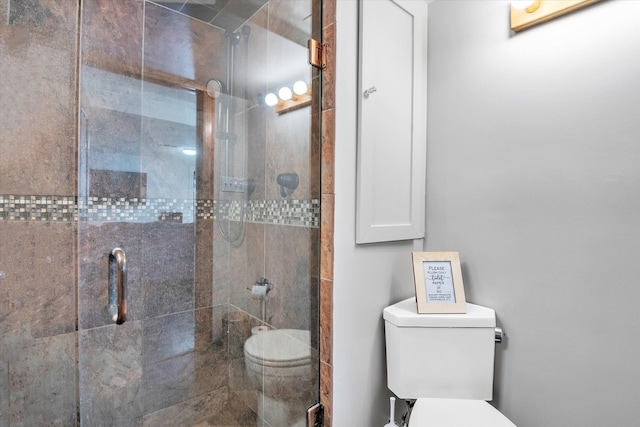 bathroom with a shower stall and toilet