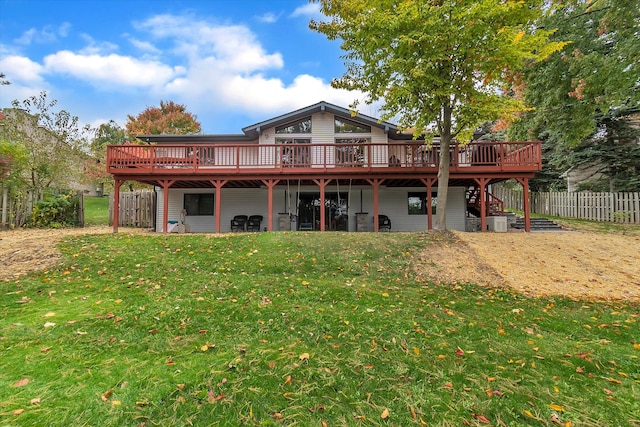 rear view of house featuring a deck, a yard, stairway, and fence