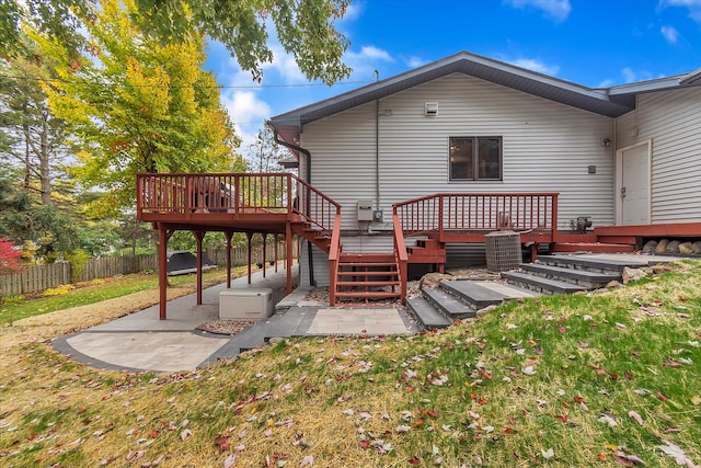 back of house with a yard, a wooden deck, fence, and a patio