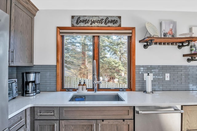 kitchen featuring light countertops, a sink, and stainless steel dishwasher