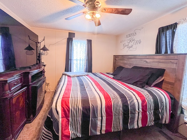 carpeted bedroom with ceiling fan and a textured ceiling