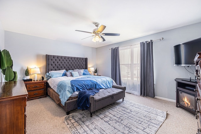 bedroom featuring light carpet, baseboards, and a ceiling fan