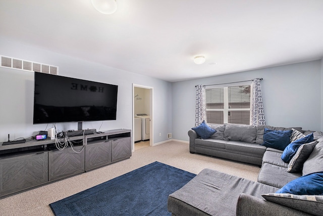 living room featuring independent washer and dryer, carpet flooring, visible vents, and baseboards