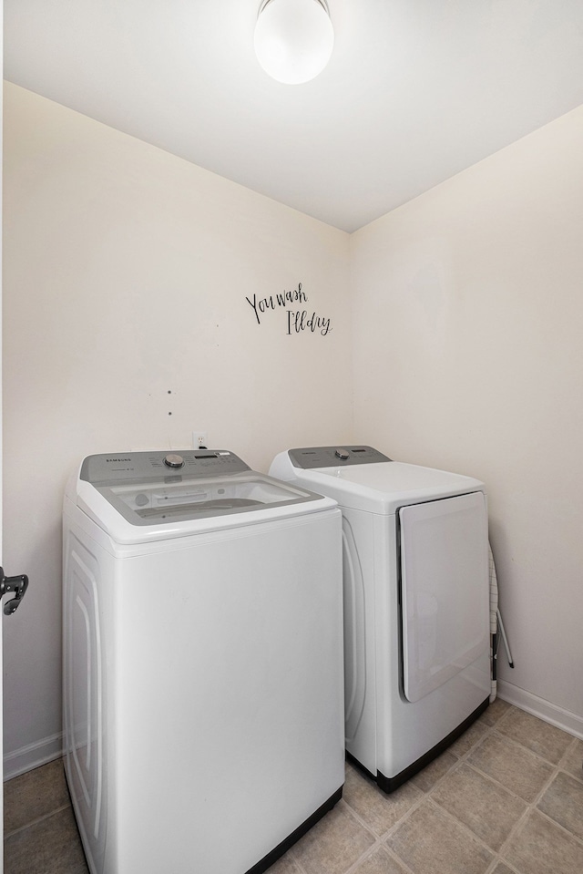 washroom with laundry area, baseboards, and washer and dryer