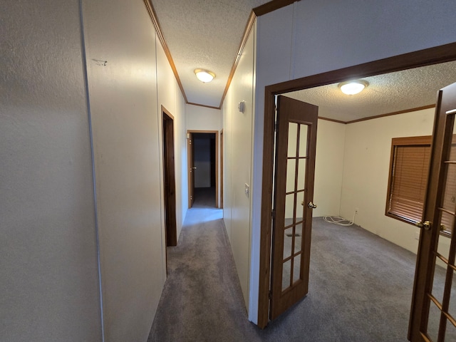 hallway featuring ornamental molding, french doors, a textured ceiling, and carpet