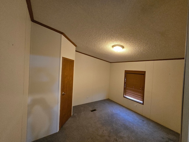 carpeted spare room featuring visible vents, crown molding, and a textured ceiling