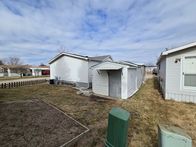 exterior space featuring a yard, a storage unit, and an outbuilding