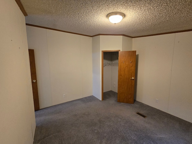 unfurnished bedroom with a textured ceiling, carpet floors, ornamental molding, and visible vents