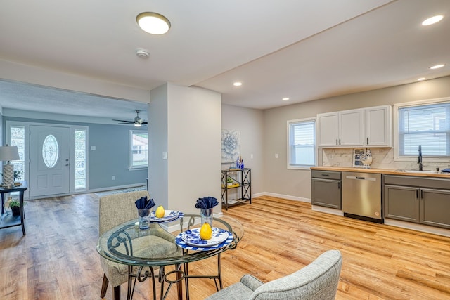 kitchen featuring a healthy amount of sunlight, dishwasher, light wood-style flooring, and a sink