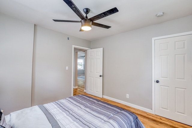 bedroom featuring ceiling fan, light wood finished floors, and baseboards