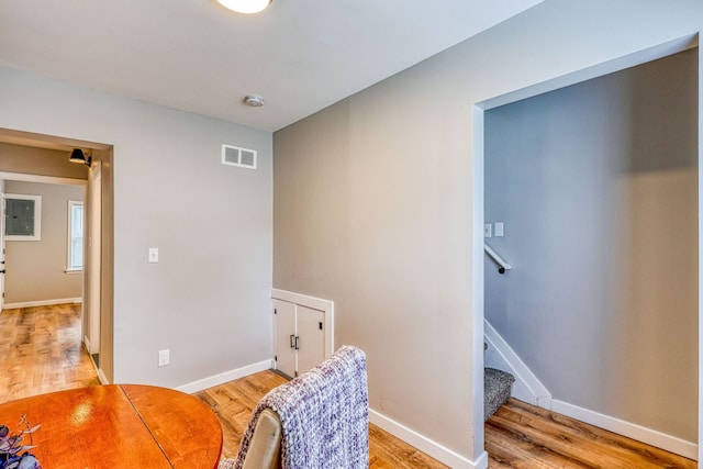 sitting room featuring baseboards, stairway, visible vents, and light wood-style floors