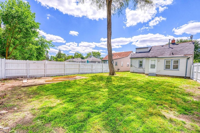 view of yard featuring entry steps and a fenced backyard