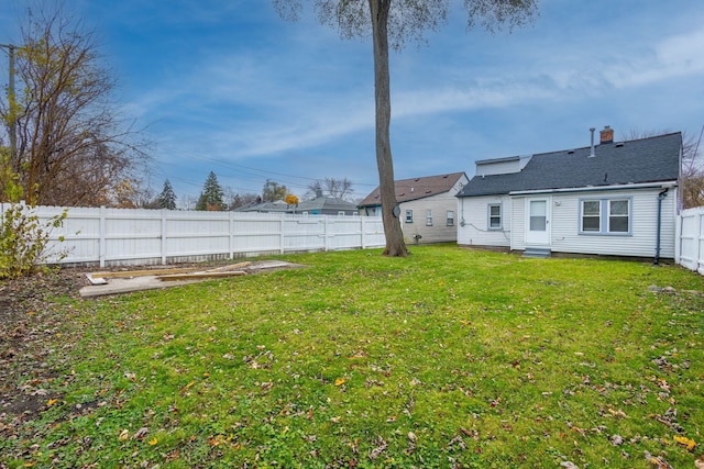 view of yard featuring entry steps and a fenced backyard