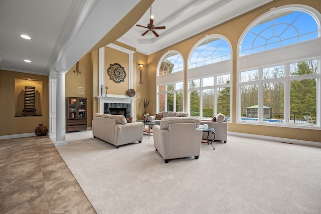 carpeted living room featuring crown molding, decorative columns, recessed lighting, a tile fireplace, and baseboards