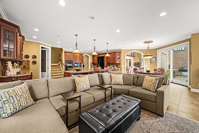 living area with arched walkways, crown molding, light tile patterned floors, recessed lighting, and stairs