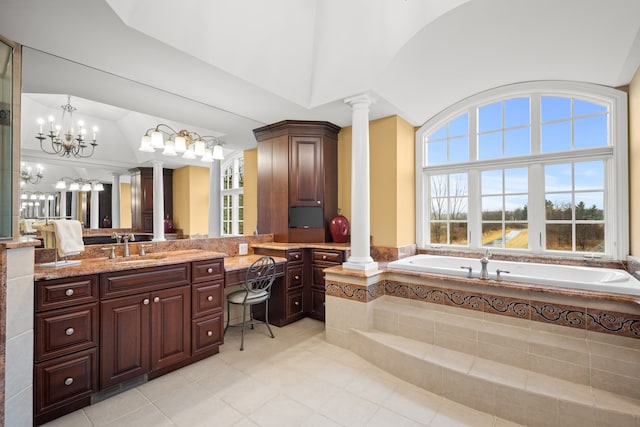 bathroom featuring lofted ceiling, a garden tub, vanity, and ornate columns