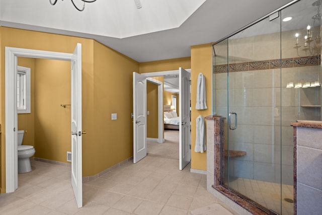 full bath with toilet, a stall shower, tile patterned flooring, and ensuite bathroom