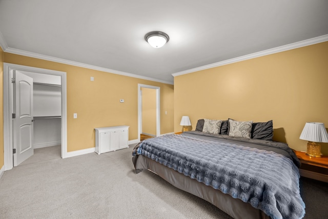 bedroom with carpet floors, a walk in closet, ornamental molding, and baseboards