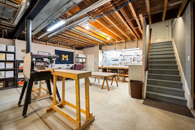 unfinished basement with stairs and a workshop area