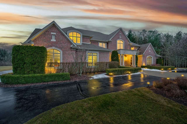 view of front of house featuring brick siding and aphalt driveway