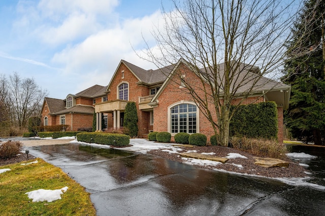 view of front of home featuring a balcony and brick siding