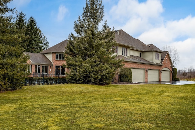 view of front of home featuring a front lawn, an attached garage, fence, and brick siding