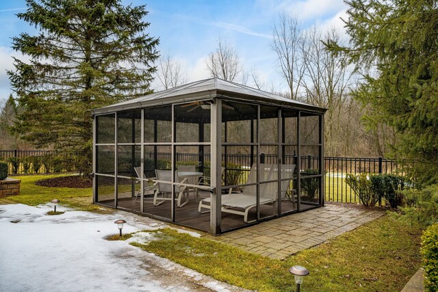 view of outbuilding with a sunroom, fence, and a gazebo