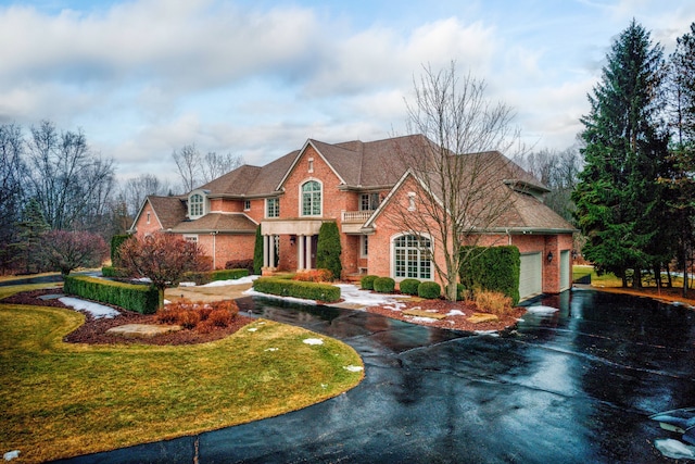 view of front of house with an attached garage, aphalt driveway, and brick siding