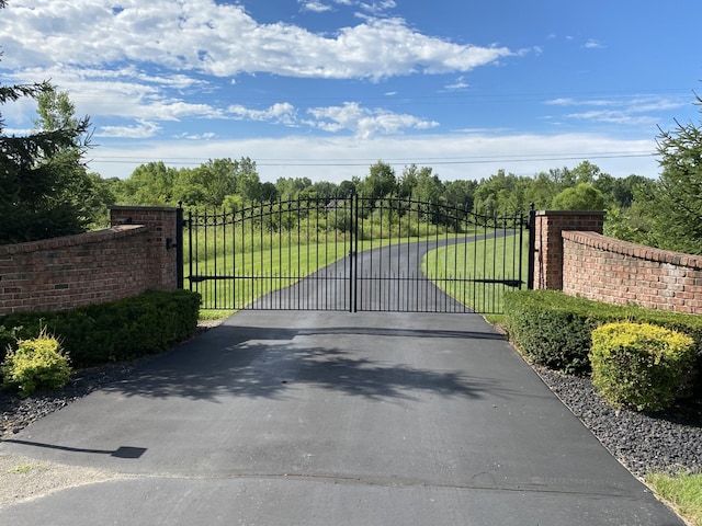 view of gate with a yard