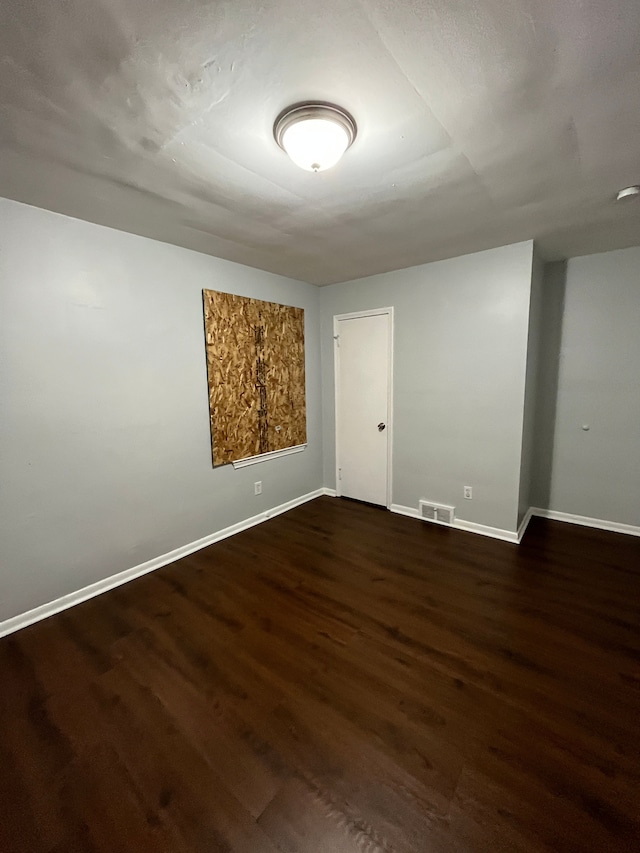 unfurnished room with visible vents, baseboards, and wood finished floors