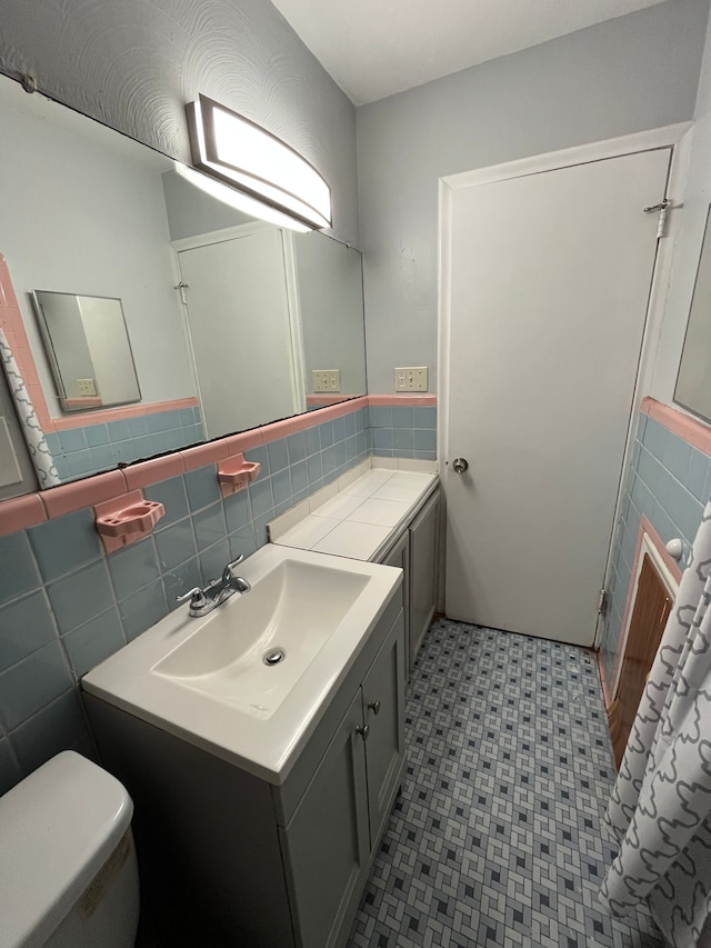 bathroom featuring tile walls, toilet, and vanity