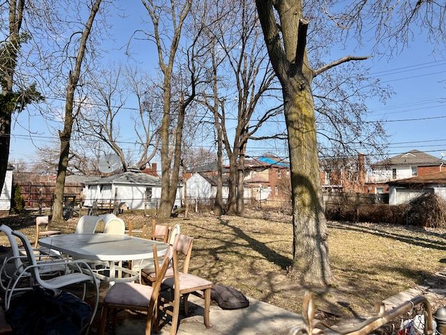 view of yard featuring a patio area, outdoor dining area, and a fenced backyard