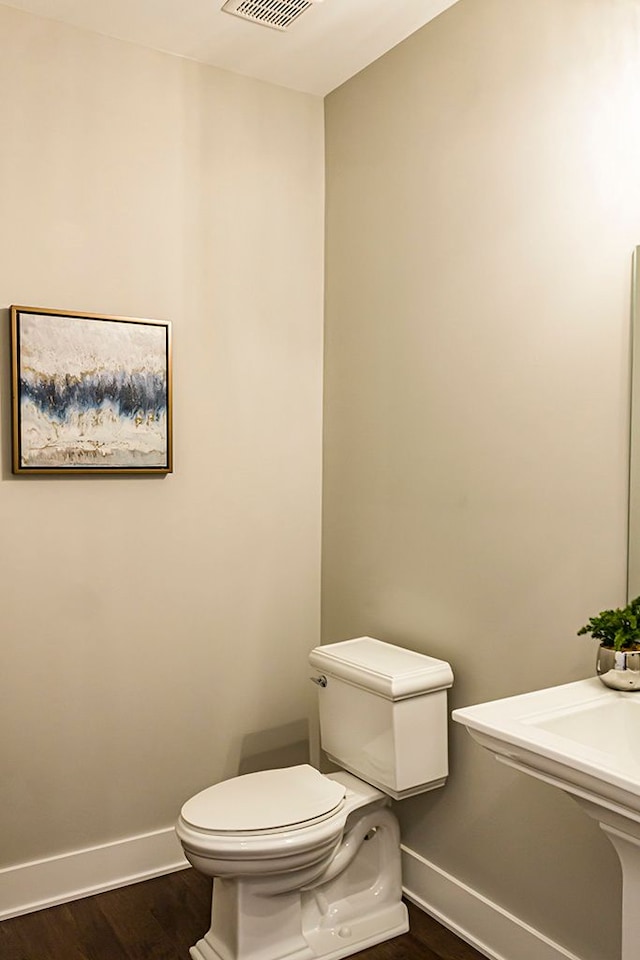 bathroom featuring baseboards, toilet, and wood finished floors