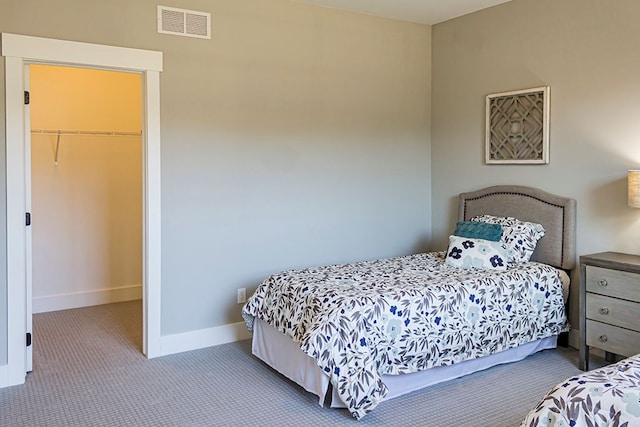 bedroom featuring carpet, a closet, visible vents, a spacious closet, and baseboards